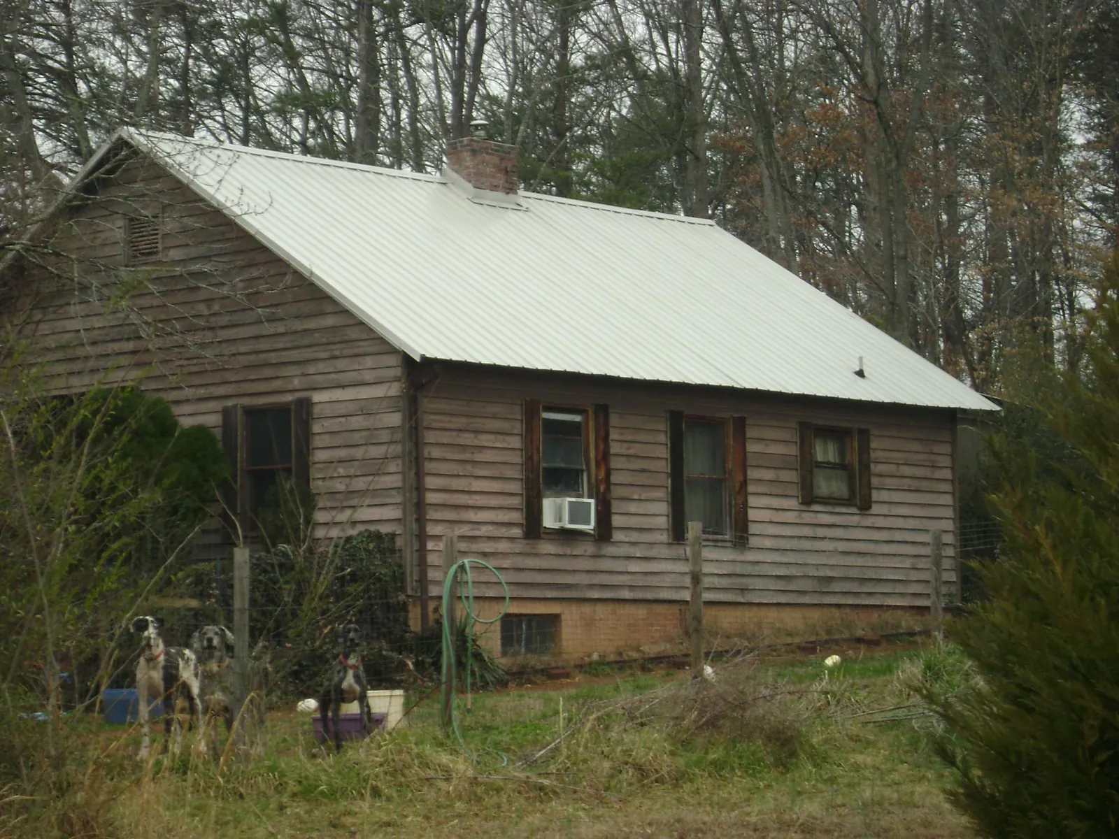 White metal roof on an old wood sided farmhouse, from a Asphalt Shingle Roof Repair job in Atkinson