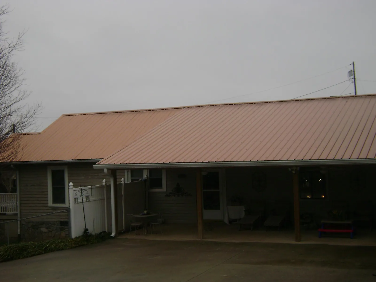 Copper toned metal roof over a wide covered patio in Atkinson